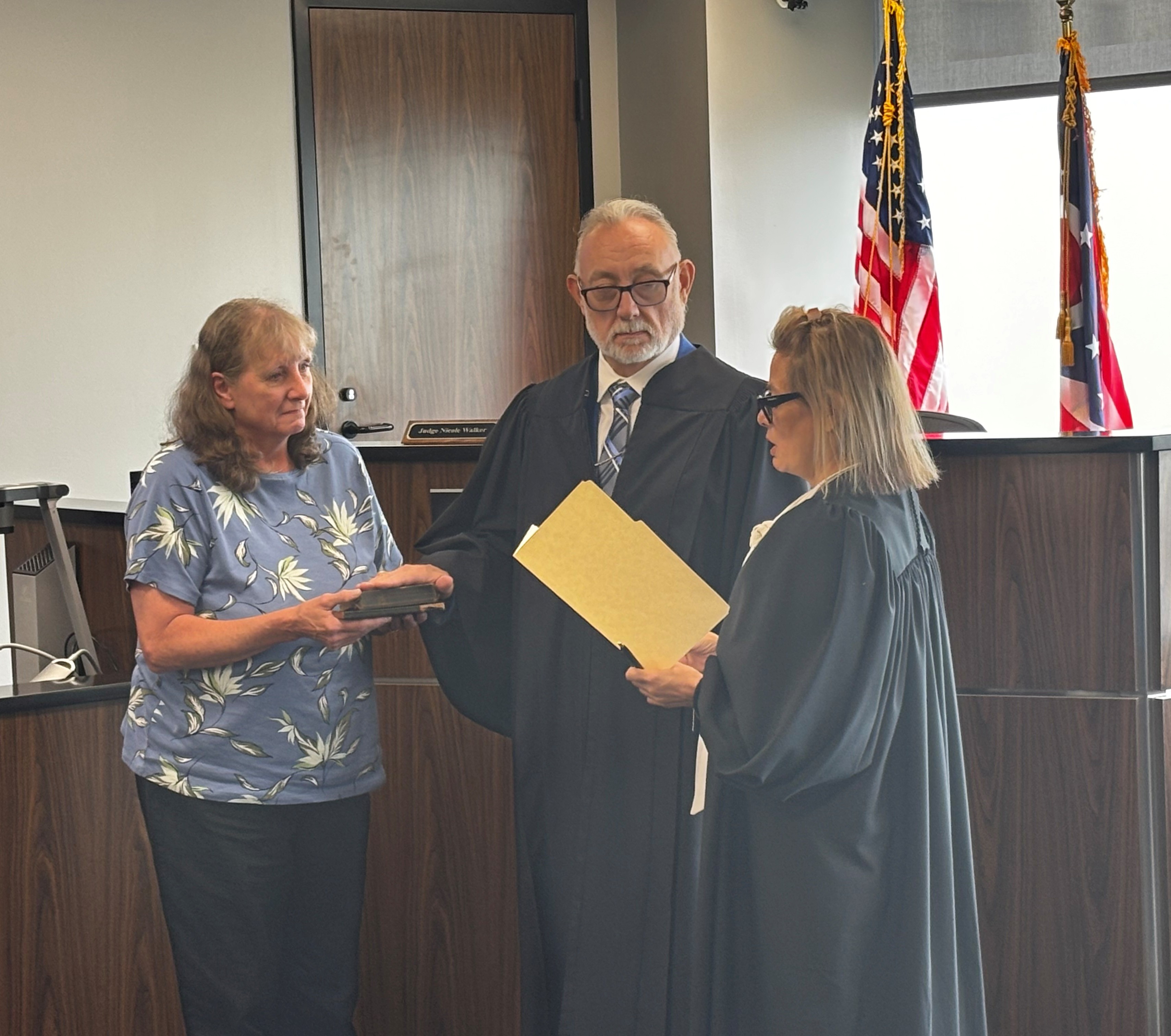 Judge Nicole Walker administers the Oath of Office to Magistrate Brian L. Coffman as his sister, Debbie Latsch, holds the family Bibles.